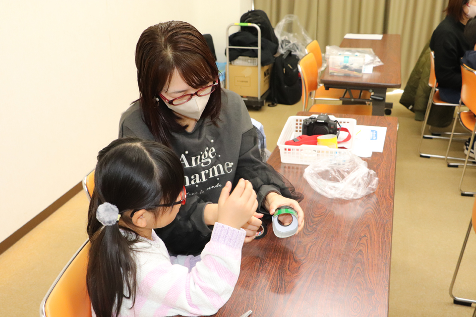 虫眼鏡でカメラのレンズを制作する様子