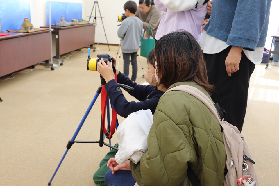 制作したレンズを一眼レフカメラにつけて撮影する様子